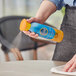 A person using SC Johnson Pledge Multi-Surface Antibacterial Cleaner to spray a table.