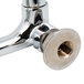 A chrome plated Equip by T&S wall mounted faucet base with a nut on the end.