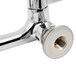 A chrome Equip by T&S wall mounted faucet base with wrist handle nuts.