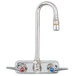 A chrome T&S wall mount faucet with two lever handles and a gooseneck spout.