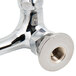A close-up of a chrome plated T&S wall mount faucet with lever handles and a nut on the end.