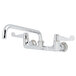 A chrome Equip by T&S wall mount faucet with wrist handles and a swing spout.