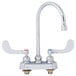 A close-up of a chrome T&S deck-mounted workboard faucet with wrist handles.