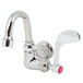 A chrome wall mounted T&S faucet with a red wrist handle.