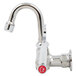 A chrome T&S wall mounted faucet with a red wrist handle and red valve.