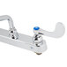 A white T&S deck-mounted workboard faucet with blue wrist handles.