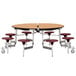 A National Public Seating round cafeteria table with a metal base and seats on wheels.