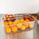 A Carlisle clear plastic food pan full of oranges.