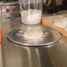 An American Metalcraft heavy weight aluminum pizza pan with dough on it.