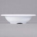 A white Carlisle melamine fruit bowl with a rim on a gray background.