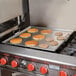 A Vigor portable steel griddle with pancakes cooking on it.