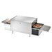 A Vollrath countertop conveyor pizza oven with pizzas cooking on it.