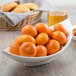 A white porcelain bowl filled with oranges.