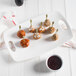 A white porcelain coupe platter with meatballs and dipping sauce on it.