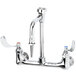 A T&S chrome wall mounted laboratory faucet with wrist handles and a swivel spout.