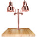 A Hanson Heat Lamps bright copper carving station on a maple surface.