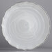 A white scalloped glass charger plate with a silver rim.