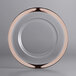 A clear glass charger plate with a copper rim.