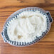 A Dart clear plastic container filled with mashed potatoes with a clear dome lid.