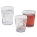A group of Dinex translucent plastic cups with white lids.