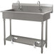 An Advance Tabco stainless steel hand sink with three toe operated faucets.
