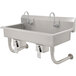 A large stainless steel Advance Tabco multi-station hand sink with knee operated faucets.