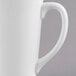 A close-up of a Libbey white porcelain tall bistro mug with a white handle.