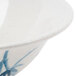 A close-up of a Thunder Group Blue Bamboo melamine bowl with a blue and white painted surface.