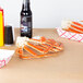 A table covered with brown paper with crab legs and a bottle on it.