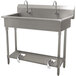 An Advance Tabco stainless steel hand sink with two bowls and two toe-push faucets.