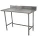 An Advance Tabco stainless steel work table with a backsplash and galvanized legs.