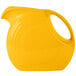 A yellow Fiesta pitcher with a white handle.