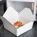 A white Fold-Pak Bio-Pak take-out box filled with food.