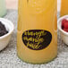A glass of orange juice with berries marked with a Franmara metallic gold marker.