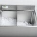 A stainless steel Regency ice bin partition filled with ice on a counter.