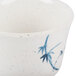 A close-up of a blue and white Thunder Group Blue Bamboo melamine tea cup.