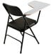 A black National Public Seating folding chair with a gray desk attachment.