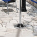 A metal stanchion base on a stone surface.