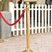 A gold pole with a red rope tied to it.