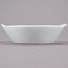 A white CAC porcelain boat bowl with a handle on a gray surface.