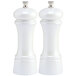 Two white salt and pepper mills with black knobs.