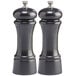 Two black pepper mills with silver caps.