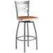 A Lancaster Table & Seating swivel bar stool with a cherry wood seat and metal frame.