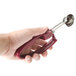 A hand holding a purple Zeroll EZ Squeeze ice cream scoop with a red handle.