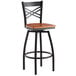 A Lancaster Table & Seating black and cherry wood swivel bar stool with a cross backrest.