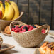 A 10 Strawberry Street Tiger Eye porcelain bowl with cut-out handles filled with a variety of fruit and pastries.