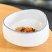 A 10 Strawberry Street Arctic Blue porcelain demi bowl filled with food on a table.
