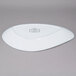 A white oval porcelain platter with an irregular shape and a logo in black.