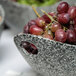 A 10 Strawberry Street granite porcelain bowl with cut-out handles filled with red grapes.