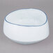 A white 10 Strawberry Street porcelain cereal bowl with a blue rim.